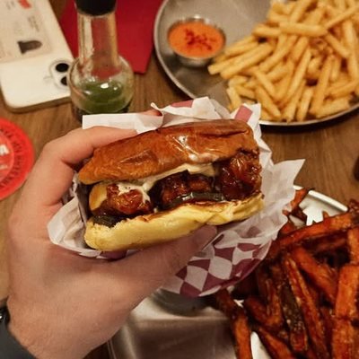 Bocadillo de pollo frito de POYO en la mano, publicado en Instagram.